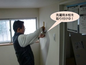 洗濯用水栓を取り付け中