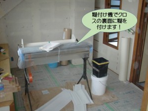 糊付け機でクロスの裏面に糊を付けます