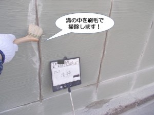 溝の中を刷毛で掃除します