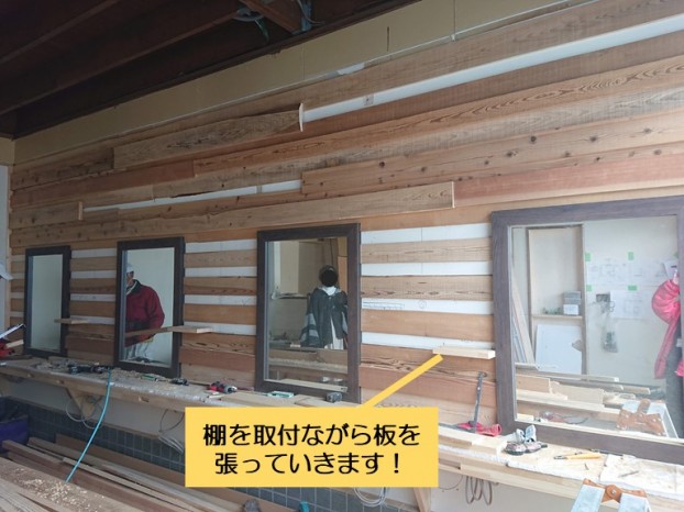 和泉市の美容室の壁に棚を取付けながら板を張ります
