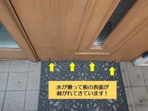 和泉市の玄関ドアに水が廻って板の表面が剥がれています