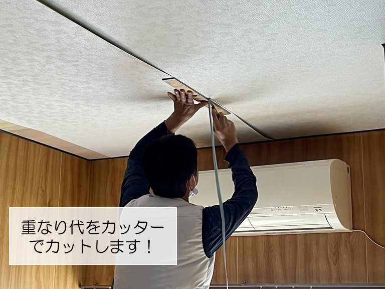 岸和田市で天井に貼ったクロスの継ぎ目をカッターでカット